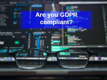 Image of glasses in front of computer screen with lots of data and banner asking are you GDPR compliant?